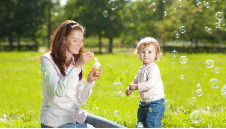 mamá con su bebé en el parque haciendo burbujas