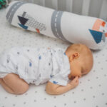 Baby sleeping on his stomach at crib
